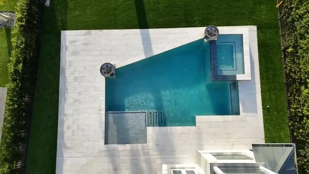 Vista aérea de una piscina rodeada de grama sintética