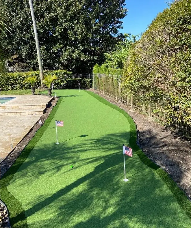 Putting green en el patio trasero con banderas de golf